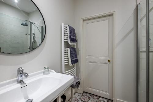 a white bathroom with a sink and a mirror at Château de Charnizay in Charnizay