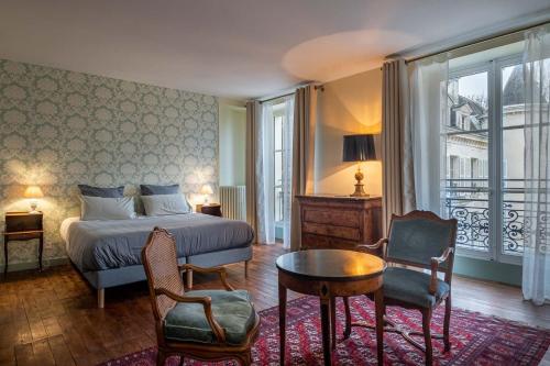 a bedroom with a bed and a table and chairs at Château de Charnizay in Charnizay