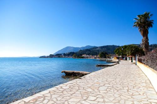 a stone walkway next to a body of water at Ligia Waterfront Apartments in Lygia