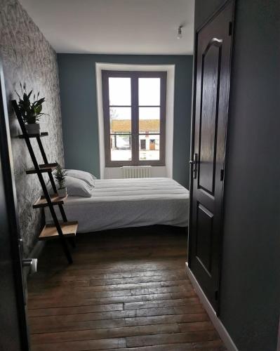 a bedroom with a bed and a window at Domaine de la Ferme de Jean Grogne in Fontenay-Trésigny