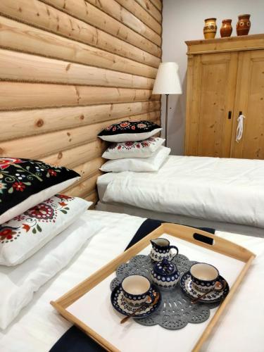 ザコパネにあるAnielki Apartamentのベッド2台、トレイ(カップ、ソーサー付)が備わる客室です。