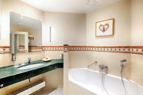 a bathroom with a sink and a bath tub at Hotel Villa Geyerswörth in Bamberg