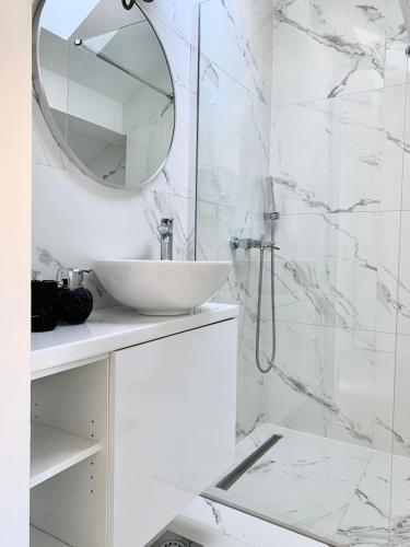 a white bathroom with a sink and a mirror at New apartman Summer in Kaštela