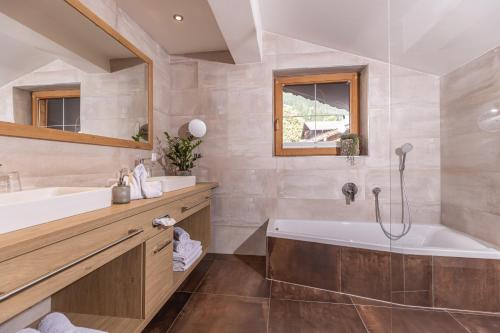 a bathroom with a tub and a sink at Das Alpbach Juwel in Alpbach