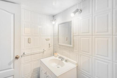 a white bathroom with a sink and a mirror at Loft Costero with Parking Wifi View & TV in Viña del Mar