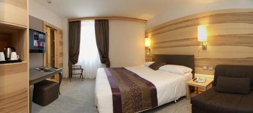 a hotel room with a bed and a chair at Hotel Garden in Peschiera del Garda