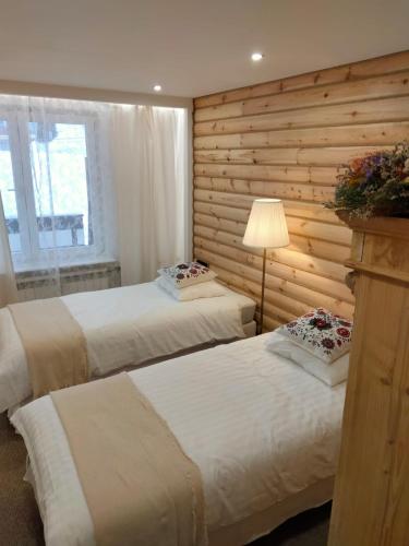 ザコパネにあるAnielki Apartamentの木製の壁のベッドルーム1室(ベッド2台付)