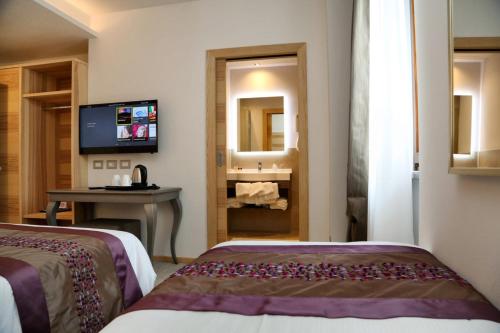 a hotel room with two beds and a television at Hotel Garden in Peschiera del Garda