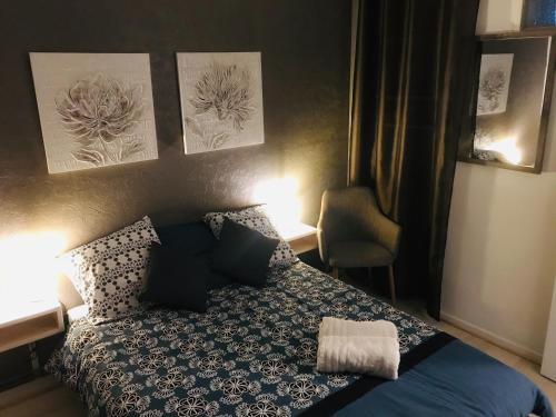 een kleine slaapkamer met een bed en een stoel bij Le bien venue chez vous in Calais