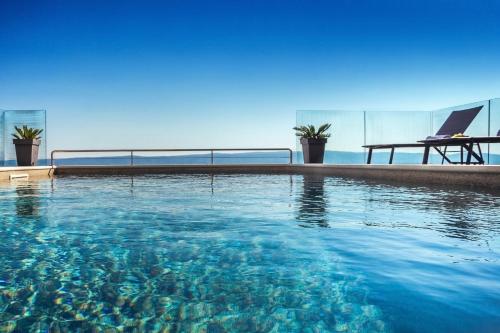 a swimming pool with a view of the ocean at Villa Dispet, sea view, pool, jacuzzi, sauna, cinema in Omiš