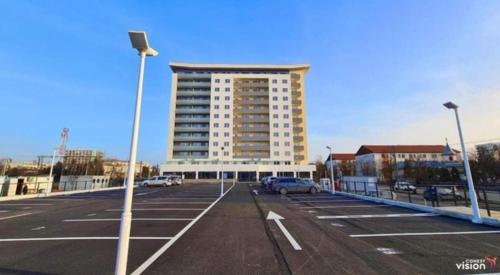 a parking lot with a large building in the background at Conest Studio in Iaşi