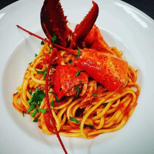 a plate of spaghetti with a lobster on top of it at L'Airone Country House in SantʼElia Fiumerapido
