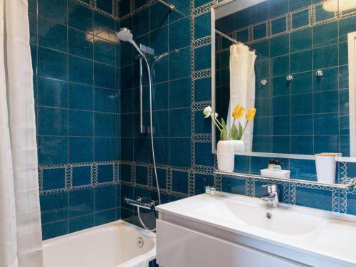 ein blau gefliestes Bad mit einem Waschbecken und einer Badewanne in der Unterkunft Clot market in Barcelona