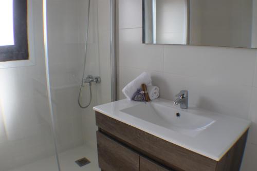 a bathroom with a sink and a shower with a mirror at Agi Montseny in Roses