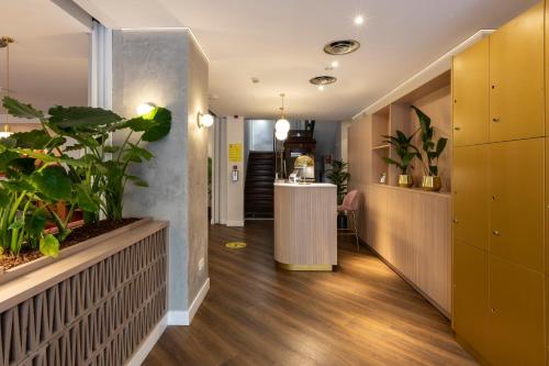 a hallway with plants and a counter in a room at Petit Palace Puerta del Sol in Madrid