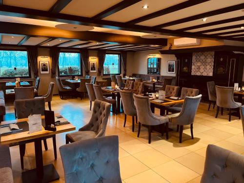 a restaurant with wooden tables and chairs and windows at Hotel Dülmener Hof in Dülmen