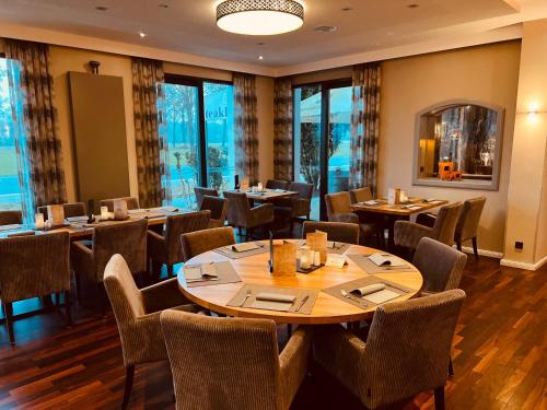 a restaurant with tables and chairs and windows at Hotel Dülmener Hof in Dülmen
