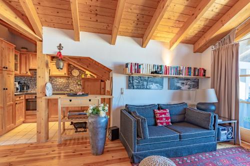 a living room with a blue couch and a kitchen at Mein Lieblingsort in Burgberg