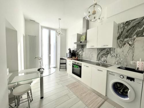 une cuisine blanche avec une machine à laver à l'intérieur dans l'établissement Mariarosa Suites, à Côme