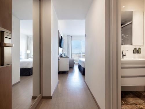 a room with two beds and a bedroom with a bathroom at Melia Sitges in Sitges