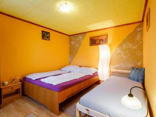 バラトンフェニヴェシュにあるKristóf Vendégházの小さなベッドルーム(ベッド2台、ランプ付)