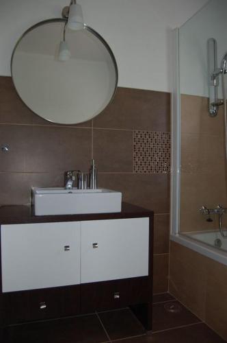bagno con lavandino bianco e specchio di Apartamento a 10 metros da praia de Albufeira ad Albufeira