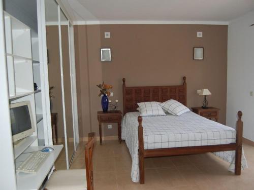 um quarto com uma cama e uma secretária com um computador em Apartamento a 10 metros da praia de Albufeira em Albufeira