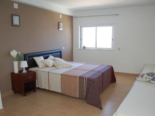 um quarto com uma cama grande e uma janela em Apartamento a 10 metros da praia de Albufeira em Albufeira