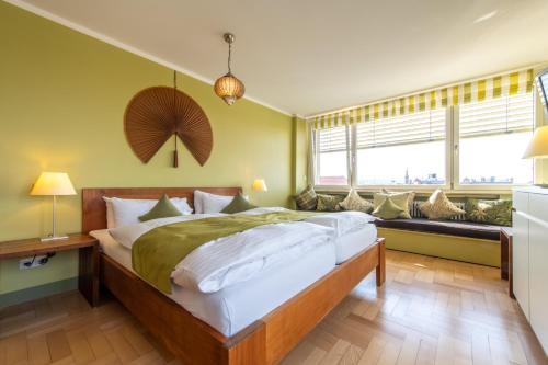 a bedroom with a large bed with green walls at Hotel Viva Sky in Konstanz