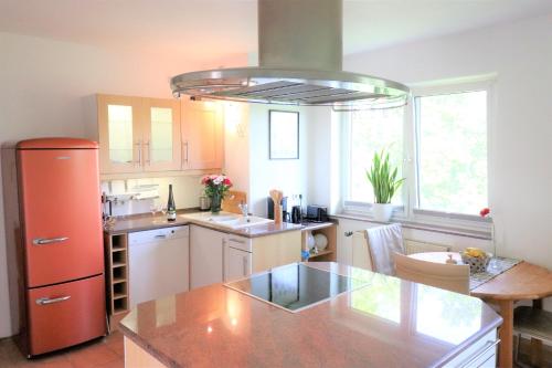 a kitchen with an orange refrigerator and a table at Gutenberg - helle und geräumige Wohnung in Uninähe in Mainz