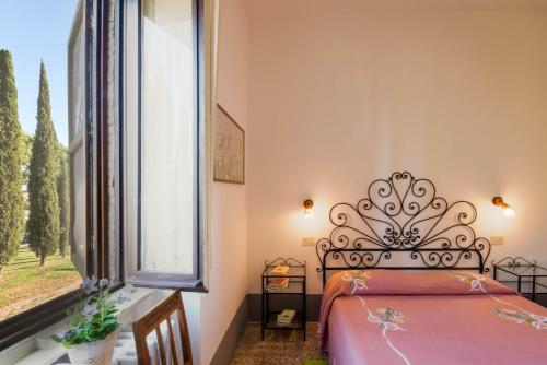 a bedroom with a bed and a large window at Tenuta di Poggio Cavallo in Istia dʼOmbrone