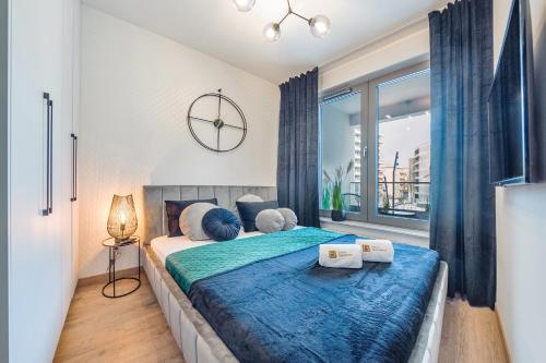 1 dormitorio con 1 cama grande con sábanas azules en Plac Unii - Premium Apartments en Gdynia