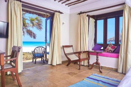 a room with a bedroom with a view of the ocean at Jacaranda Indian Ocean Beach Resort in Diani Beach