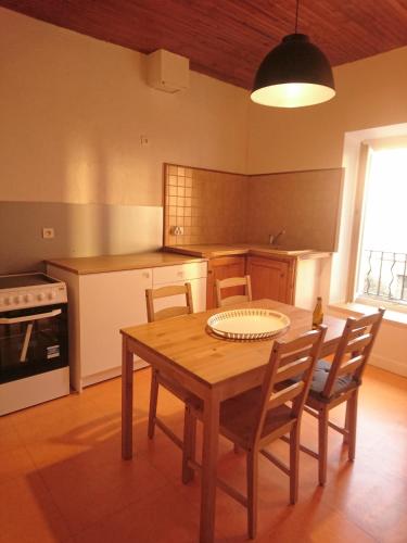 - une cuisine avec une table et des chaises en bois ainsi qu'une cuisinière dans l'établissement Appartement centre Nyons, à Nyons