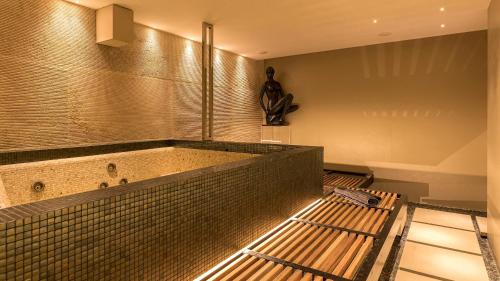a room with a hot tub with a statue on the wall at VILLA LE MANDRIE 7&2, Emma Villas in Castiglione della Pescaia