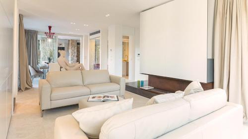 a living room with two white couches and a tv at VILLA LE MANDRIE 7&2, Emma Villas in Castiglione della Pescaia
