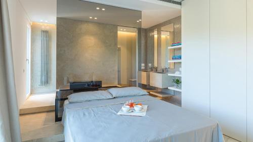 a bedroom with a bed with a tray of food on it at VILLA LE MANDRIE 7&2, Emma Villas in Castiglione della Pescaia