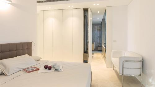 a bedroom with a bed with a tray of fruit on it at VILLA LE MANDRIE 7&2, Emma Villas in Castiglione della Pescaia