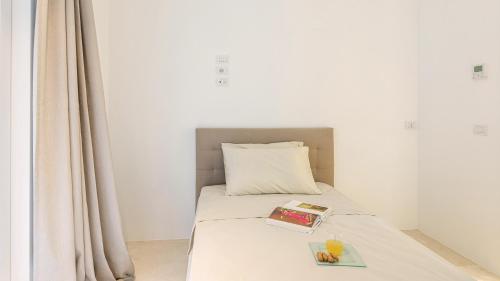 a bedroom with a bed with a book on it at VILLA LE MANDRIE 7&2, Emma Villas in Castiglione della Pescaia