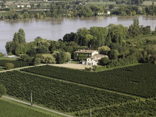 an aerial view of a house on a farm next to a river at Petit Garros in Fronsac