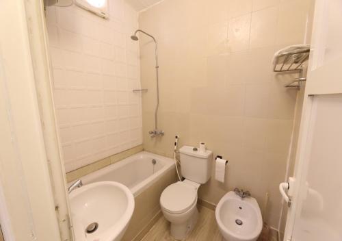 a bathroom with a toilet and a tub and a sink at منتجع قرية الفقرة in As Sudayrah