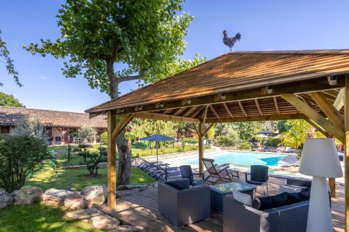 a wooden pavilion with a pool in a yard at Hotel Village Motel in Tournus