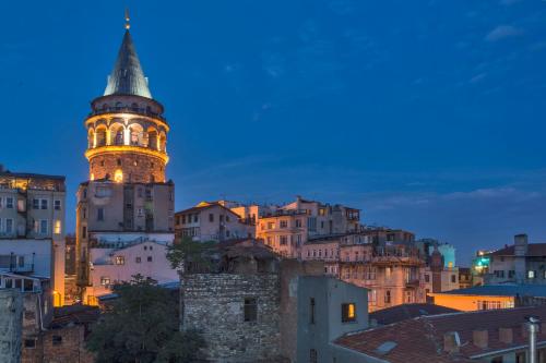 a view of a city with a clock tower at night at Galatower Hotel in Istanbul