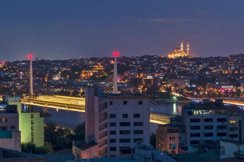 a view of a city at night with a bridge at Galatower Hotel in Istanbul