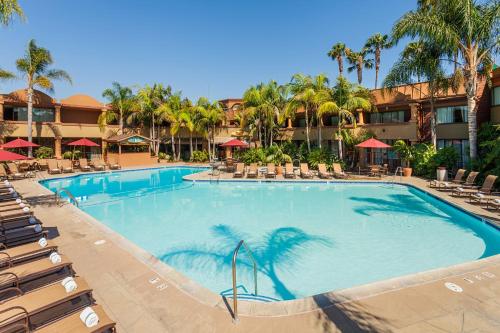 a swimming pool at a resort with chairs and palm trees at Handlery Hotel San Diego in San Diego