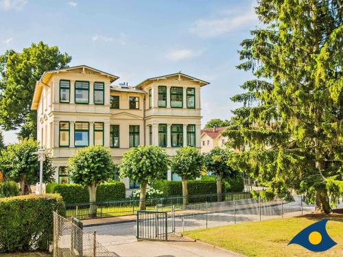 una casa grande con una valla delante en Villa Waldblick Whg 05, en Bansin