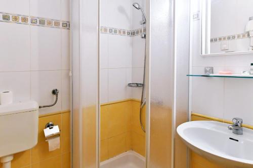 a bathroom with a shower and a sink at Hotel Stanger in Lovran
