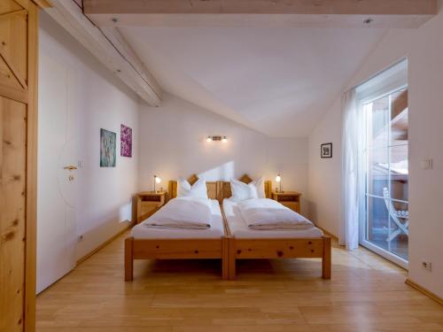 a bedroom with a bed and a large window at Ski-in, Ski-out by Apartment Managers in Kirchberg in Tirol
