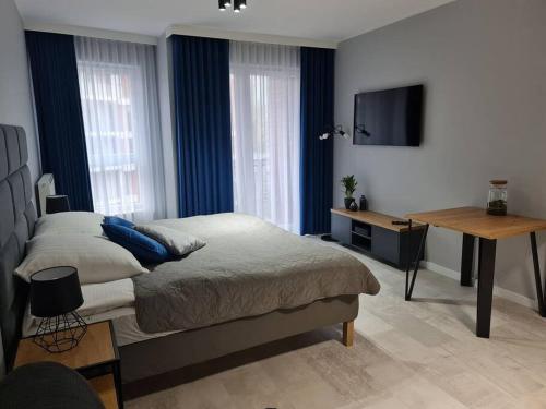 a bedroom with a bed and a flat screen tv at Bastion Apartament in Gdańsk