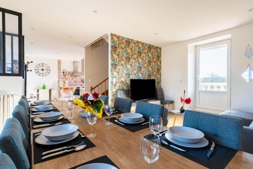 a dining room and living room with a table and chairs at Gîte le Couderc in Gabriac